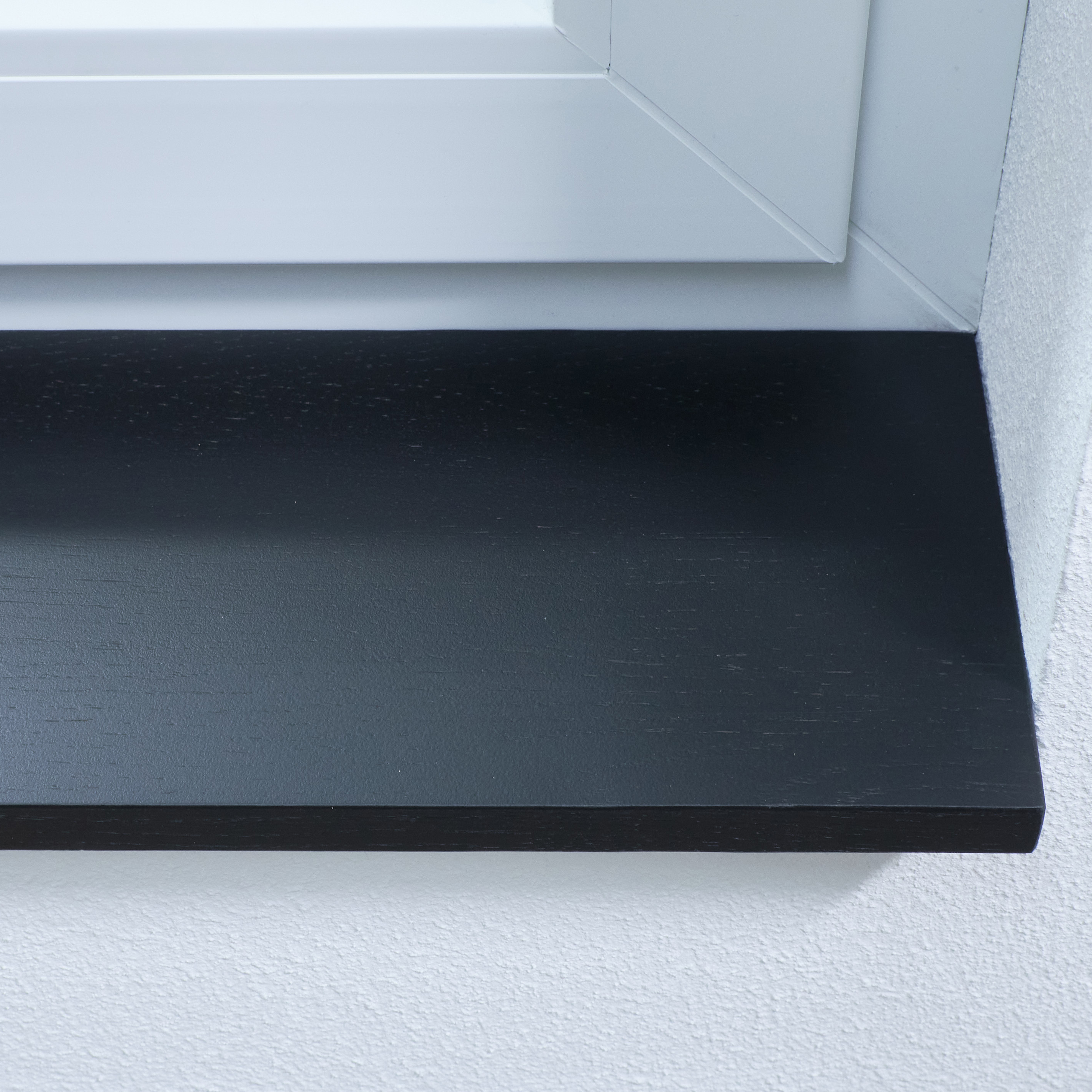 Vensterbank van eikenhout, zwart gebeitst, vingergelast, close-up van de voorkant in witte dagkant
