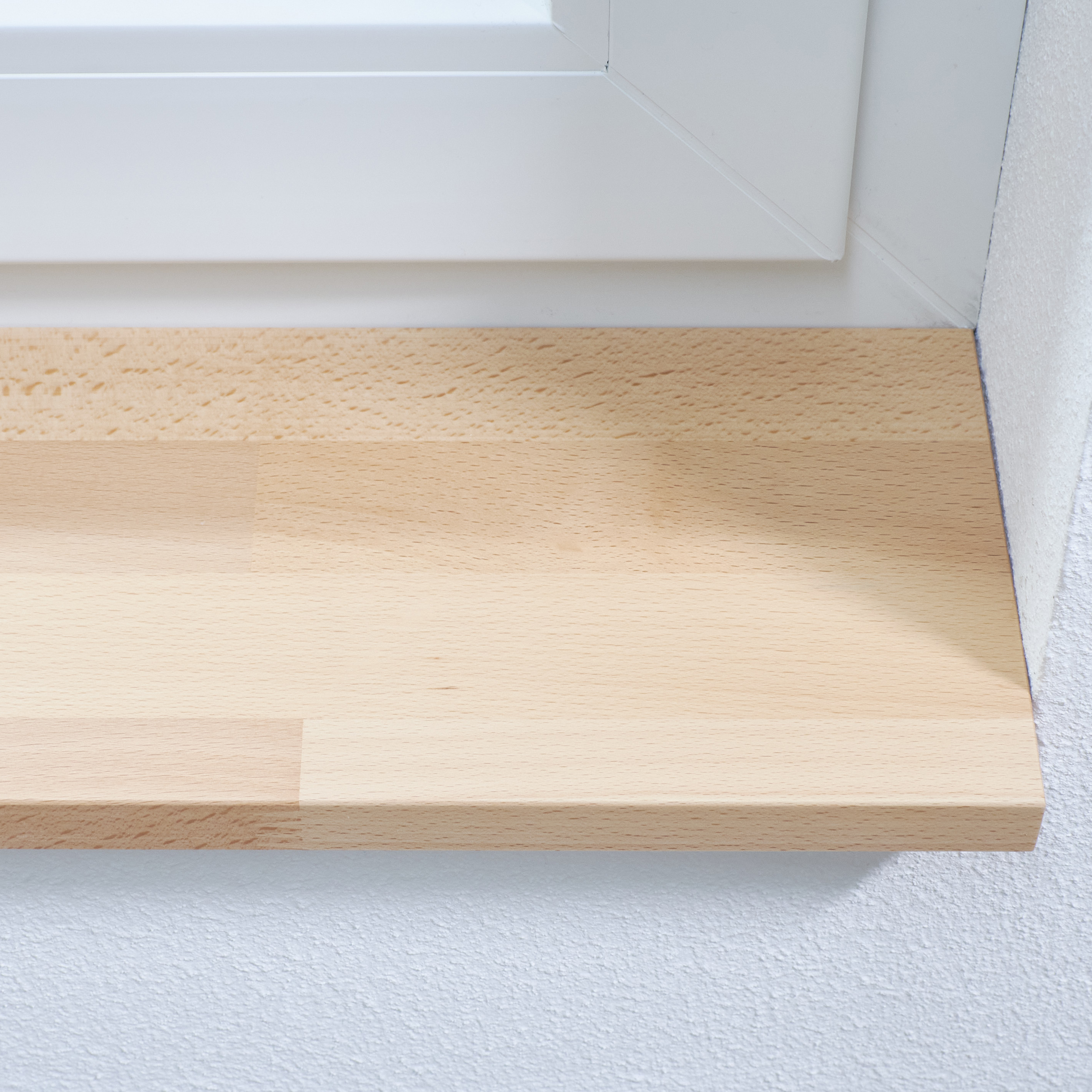 Vensterbank van beukenhout, naturel, vingergelast, close-up van de voorkant met zichtbare lamelnaden in het lichte hout