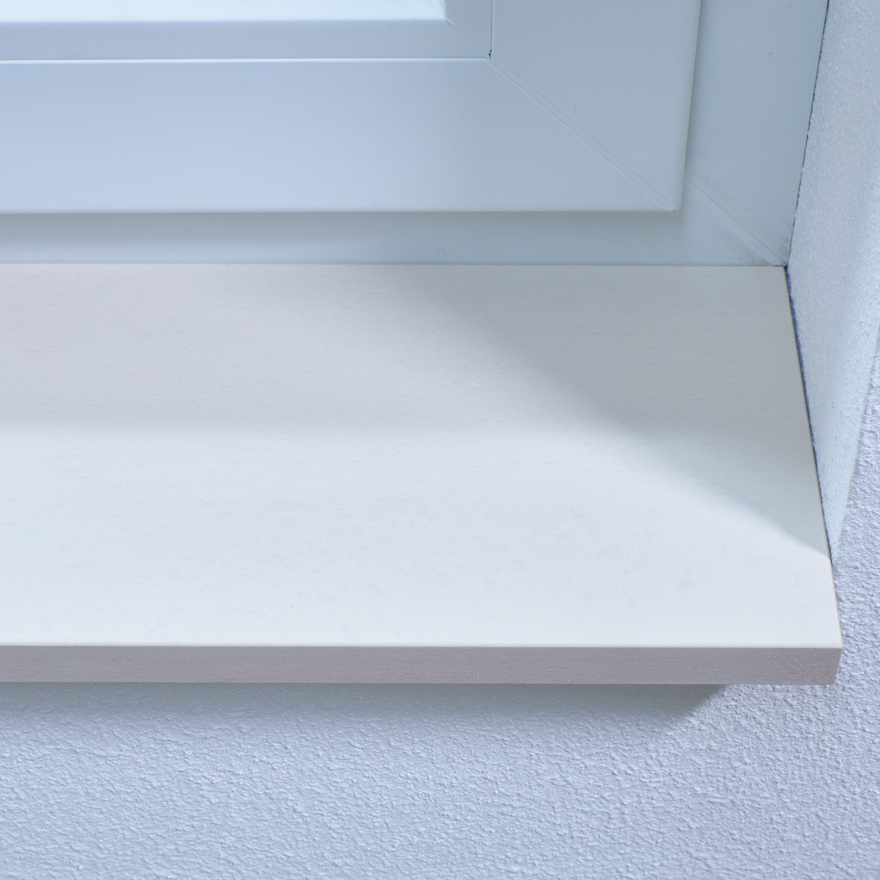 Vensterbank van beukenhout, wit gebeitst, close-up van de voorkant van de witte vensterbank bij de witte dagkant