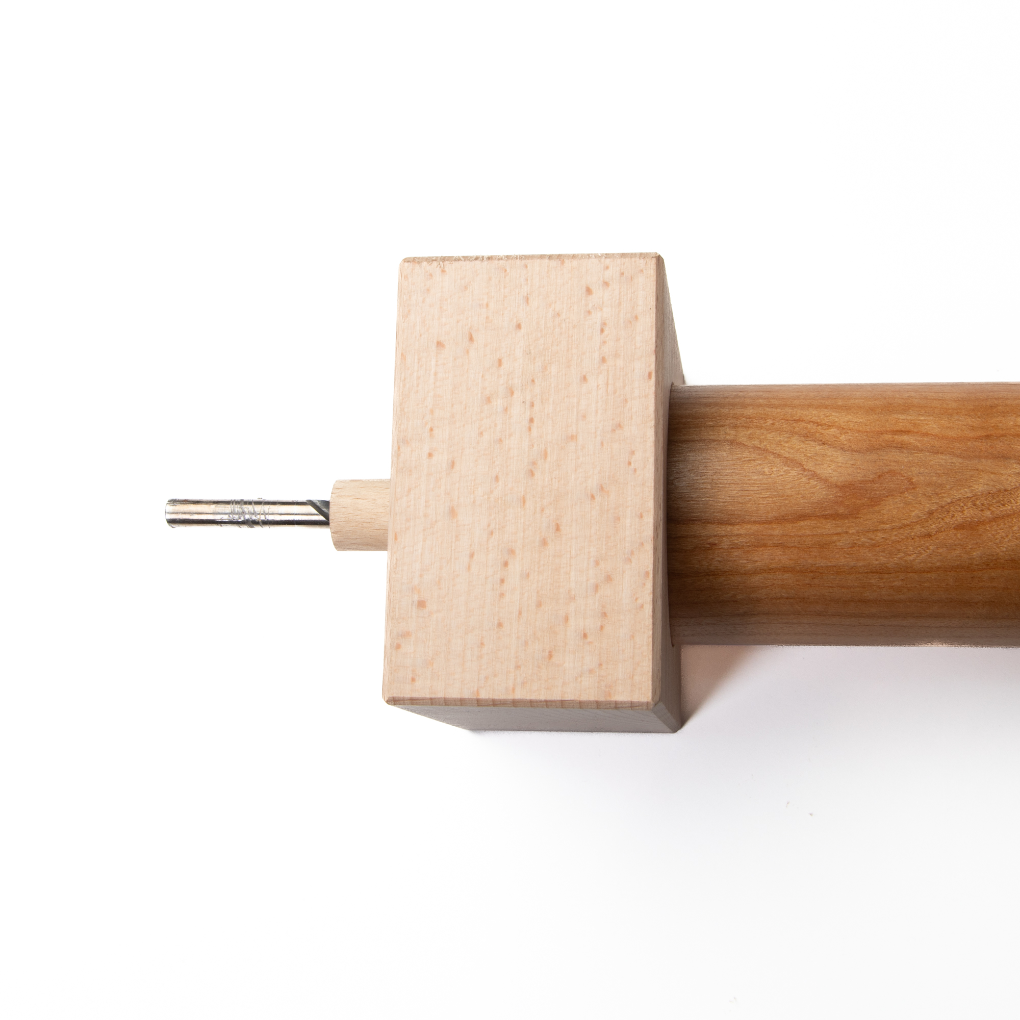 Boorsjabloon voor pluggaten zijdelings aan het leuningeinde, houtboor door het sjabloon gestoken, zijaanzicht