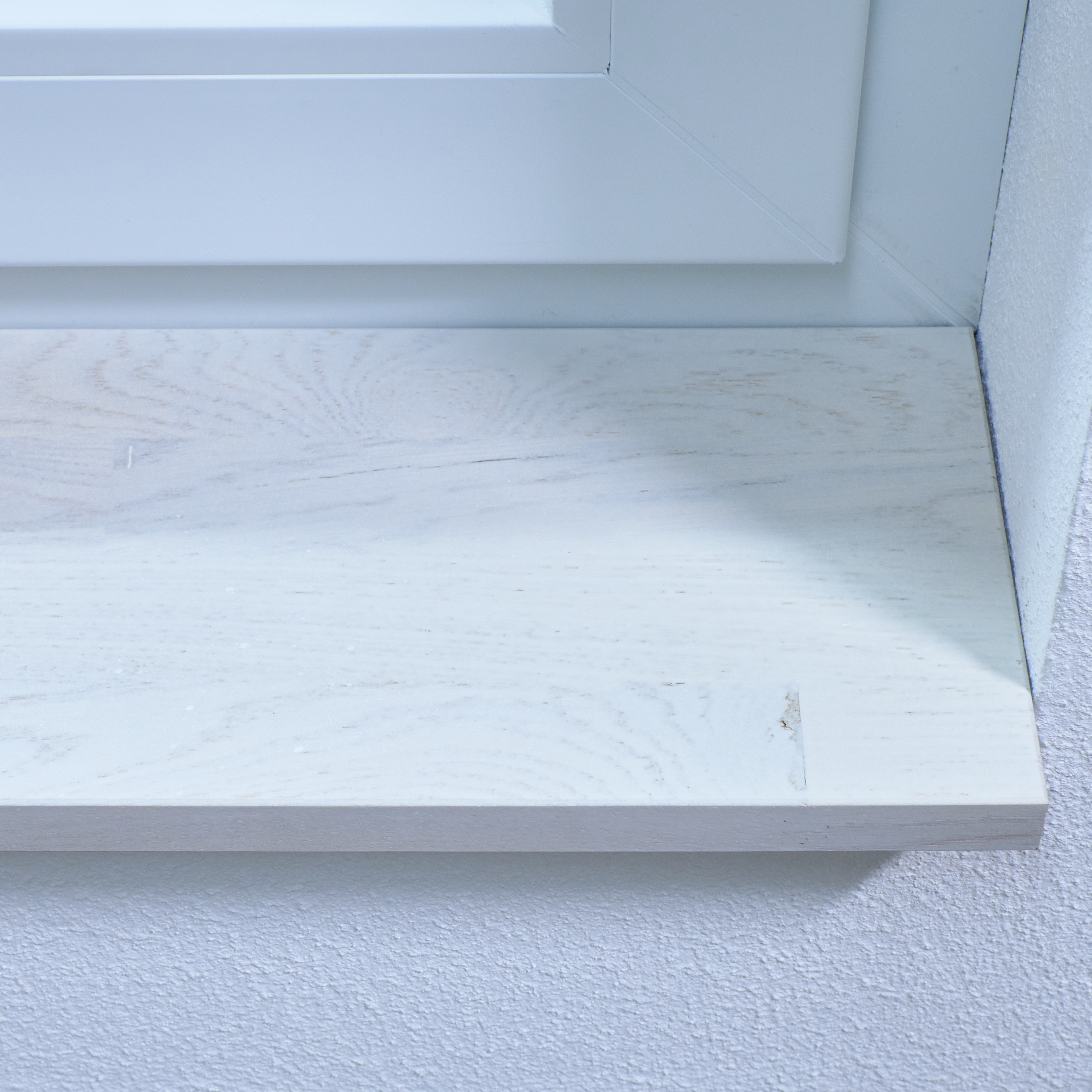 Vensterbank van wild eikenhout, wit gebeitst, vingergelast, close-up van de voorkant met nerf en kleine kwast