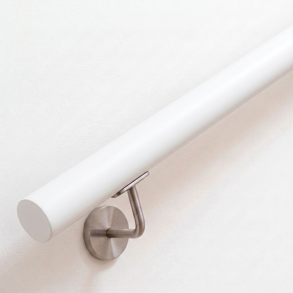 Ronde witte leuning van beukenhout, wit gelakt, met roestvrijstalen leuninghouder aan witte wand, recht uiteinde, van boven